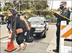  ?? Genaro Molina Los Angeles Times ?? A HOMELESS WOMAN leaves Echo Park after police closed the encampment March 25. Residents were bused to temporary housing.