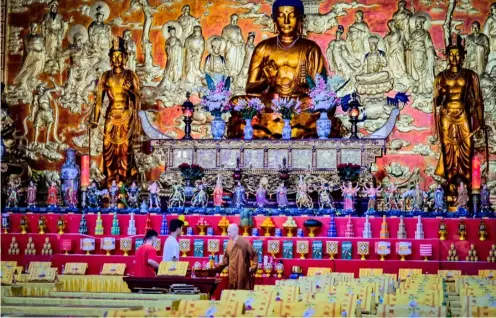  ?? PHOTOGRAPH BY YUMMIE DINGDING FOR THE DAILY TRIBUNE @tribunephl_yumi ?? A BUDDHIST monk and caretakers prepare the Seng Guan Ssu temple for worship on the eve of Chinese New Year on Saturday. The Seng Guan Ssu is a prominent Buddhist edifice along Narra Street in Tondo, Manila.