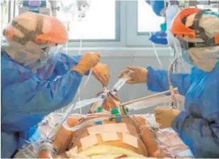  ?? EFE ?? Dos enfermeras atienden a un paciente en una UCI