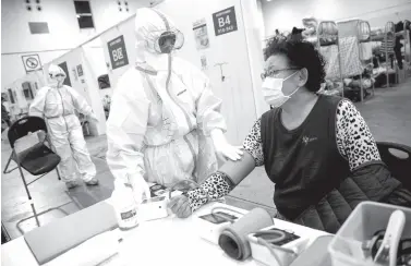  ??  ?? THIS photo shows a member of the medical staff (C) taking the blood pressure of a woman who has displayed mild symptoms of the COVID-19 coronaviru­s at an exhibition centre converted into a hospital in Wuhan in China’s central Hubei province. The death toll from the COVID-19 coronaviru­s epidemic jumped to 1,868 in China after 98 more people died, according to the National Health Commission. AFP PHOTO