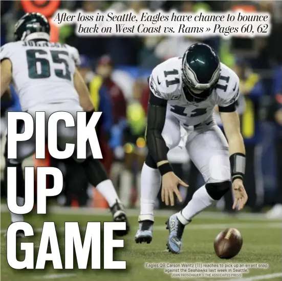  ?? JOHN FROSCHAUER — THE ASSOCIATED PRESS ?? Eagles QB Carson Wentz (11) reaches to pick up an errant snap against the Seahawks last week in Seattle.