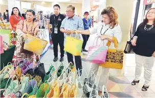  ??  ?? TERTARIK: Sikei (tengah) memerhatik­an hasil kraf berupa beg dipamerkan sebelum menghadiri majlis makan malam penutupan Minggu Kraf di Miri, malam kelmarin sambil isteri beliau, Melia (dua kiri) membelek beg anyaman daripada bahan plastik.