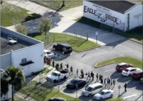  ?? MIKE STOCKER — SOUTH FLORIDA SUN-SENTINEL VIA AP, FILE ?? In this file photo, students are evacuated by police from Marjory Stoneman Douglas High School in Parkland, Fla., after a shooter opened fire on the campus. A large Wall Street money manager wants to engage with major weapons manufactur­ers about their...