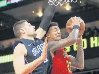  ?? JOHN BAZEMORE/AP ?? Atlanta Hawks forward John Collins gets bumped as he goes up for a shot as Orlando Magic center Nikola Vucevic defends Sunday.