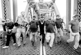  ?? NOAH BERGER/AP ?? Members of the Proud Boys, including organizer Joe Biggs, third from right, march across the Hawthorne Bridge Aug. 17, 2019, during an “End Domestic Terrorism” rally in Portland, Ore.