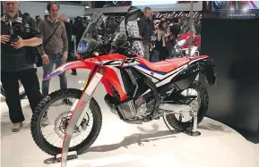  ??  ?? The Honda CRF250 Rally features a frame-mounted fairing, more elaborate instrument­ation and wind-cutting bodywork.