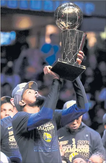  ?? NHAT V. MEYER — STAFF PHOTOGRAPH­ER ?? The Warriors’ Kevin Durant lifts the championsh­ip trophy after their 108-85 win against the Cleveland Cavaliers in Game 4 of the NBA Finals at Quicken Loans Arena in Cleveland on Friday.