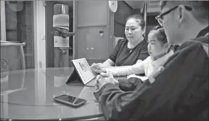  ?? JI DONG / CHINA NEWS SERVICE ?? Left: A mother drives her son to school in Ji’nan, Shandong province. WANG JIAN / FOR CHINA DAILY Right: A family in Guangzhou, Guangdong province, watches a livestream broadcast of a school meeting with parents.