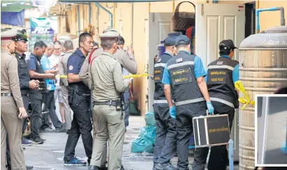  ?? PORNPROM SATRABHAYA ?? A forensics team enters a garment shop in Soi Chula 10 in Bangkok’s Pathumwan district to collect evidence after Ekachai Jaruksin, 48, fired dozens of shots into the street yesterday morning.