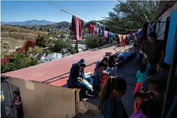  ?? Associated Press ?? ■ Migrants rest Oct. 31 at “La Roca,” or The Rock shelter, in Nogales, Sonora state, Mexico. The shelter sits next to the border fence, top left, that separates Mexico from the U.S.