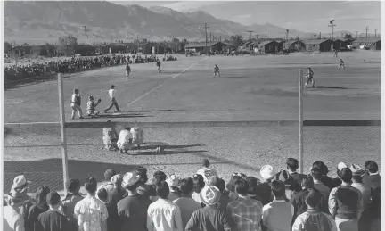  ?? ANSEL ADAMS VIA LIBRARY OF CONGRESS ?? A baseball game takes place at Manzanar, an internment camp where Japanese Americans were forcibly relocated during World War II in the California desert.