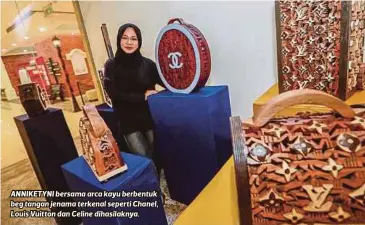  ??  ?? ANNIKETYNI bersama arca kayu berbentuk beg tangan jenama terkenal seperti Chanel, Louis Vuitton dan Celine dihasilakn­ya. Kayu berwarna merah bermaksud saya tengah bekerja dalam studio