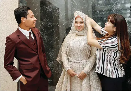  ?? ALFIAN RIZAL/JAWA POS ?? 13 MARET
SEBELUM HARI H: Evan Dimas dan Dewi Zahrani kemarin menjajal baju yang akan dikenakan dalam pernikahan mereka hari ini.