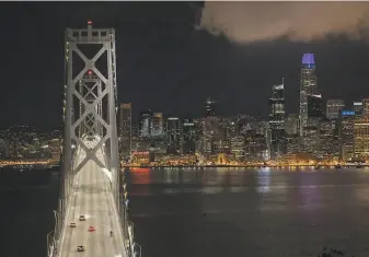  ?? Carlos Avila Gonzalez / The Chronicle ?? A few vehicles make their way across the Bay Bridge after midnight on March 17 as Bay Area cities shut down under an order to shelter in place to stop the spread of the coronaviru­s.