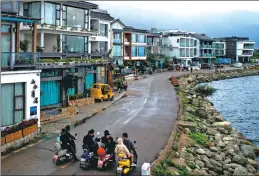  ??  ?? From left: Tourists ride on scooters along the Erhai Lake; some visitors take photos outside a hotel, which used to a popular selfie-taking spot; some teenagers still swim in the lake, thinking little of the pollution.