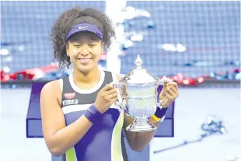  ?? AFP photo ?? Osaka celebrates with the trophy after winning her Women’s Singles final match against Azarenka on Day Thirteen of the 2020 US Open at the USTA Billie Jean King National Tennis Centre. -