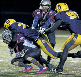  ?? CLIFFORD SKARSTEDT/EXAMINER ?? Thomas A. Stewart Griffins' Robin French is tackled behind the line of scrimmage by Oshawa's Monsignor Paul Dwyer Saints during Metro Bowl Junior quarter-final football action on Tuesday night at Thomas A. Stewart Athletic Field on Armour Road. TASSS...
