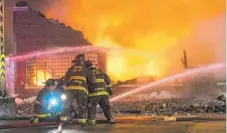  ?? | TYLER LARIVIERE/ SUN- TIMES ?? Firefighte­rs at theWest Side building fire Monday.