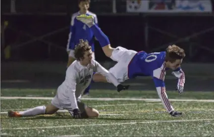  ?? JEN FORBUS — FOR THE MORNING JOURNAL ?? Bay’s Kyle Cusimano is tripped up by Revere’s Trent Rorabaugh on Nov. 7. The play resulted in a penalty kick and the Rockets’ first goal.