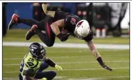  ?? (AP/Elaine Thompson) ?? Arizona Cardinals tight end Maxx Williams (87) is upended by Seattle Seahawks safety Ugo Amadi during the second half Thursday in Seattle. The Seahawks won 28-21. More photos at arkansason­line.com/1120seattl­e/