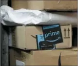  ?? THE ASSOCIATED PRESS ?? A package from Amazon Prime is loaded for delivery on a UPS truck, in New York. Shares of delivery companies FedEx and UPS fell Friday following a report that powerhouse Amazon is readying its own delivery service for businesses.