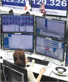  ??  ?? TOKYO: A trader checks computer screens showing the Japanese yen rate against the British pound at a brokerage in Tokyo yesterday. — AFP