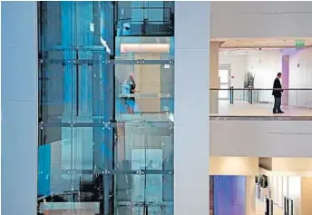  ?? AMY BETH BENNETT/STAFF PHOTOGRAPH­ER ?? The UTC Center in Palm Beach Gardens features glass-encased, energy-efficient Otis elevators and escalators.