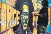  ?? STEPHEN MATUREN GETTY IMAGES ?? An artist paints a mural of George Floyd near where he was killed while in police custody in Minneapoli­s.