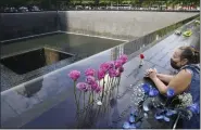  ?? JOHN MINCHILLO — ASSOCIATED PRESS FILE ?? In a Sept. 11, 2020, photo, a mourner prays over the etched name of Emilio Pete Ortiz at the National September 11 Memorial and Museum in New York.