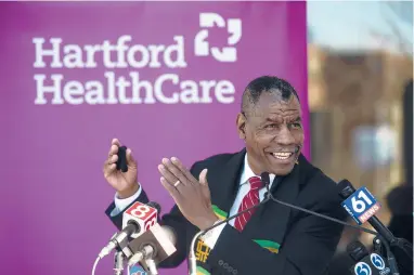  ?? KASSIJACKS­ON/HARTFORD COURANT ?? The Rev. Carl McCluster, senior pastor at Shiloh Baptist Church, speaks before receiving his first dose of the COVID-19 vaccine outside St. Vincent’s Medical Center on Friday in Bridgeport.