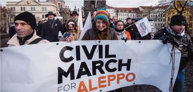  ??  ?? PRAGUE: People hold a banner reading Civil march for Aleppo while taking part in a solidarity civil march for Aleppo yesterday in Prague.