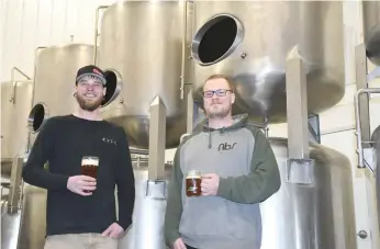  ??  ?? Brothers Cody and Cory Schulze gather in front of some of the fermenting machines that will make craft beer for Moose Jaw’s first microbrewe­ry. The Moose Jaw Brewing Company plans to launch in the spring with a soft opening to determine how much demand there is in town for the barley-based suds. Photo by Jason G. Antonio