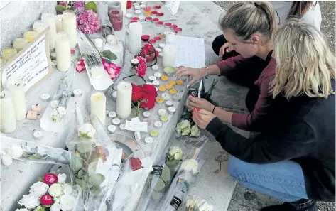  ?? FRANCOIS MORI/THE ASSOCIATED PRESS ?? Flowers, candles and messages are placed on the city hall entrance close to the home of Rev. Jacques Hamel after he was killed during an attack in a church in Saint-Etienne-du-Rouvray, Normandy, France. Two attackers invaded a church Tuesday during...