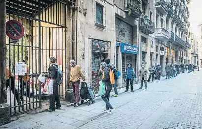  ?? EEIBERT TEIXIDÓ ?? Un grup de persones fan cua davant l’església de Santa Anna de Barcelona per anar a buscar menjar
