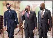  ?? J. Scott Applewhite / Associated Press ?? Senate Majority Leader Chuck Schumer, D-N.Y., center, is joined by Sen. Jon Ossoff, D-Ga., left, and Sen. Raphael Warnock, D-Ga., for a news conference to discuss the COVID relief bill, at the Capitol in Washington on Thursday.