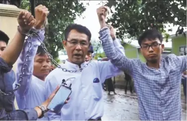  ?? Democratic Voice of Burma ?? Journalist­s show their shackles after being arrested under Myanmar’s Unlawful Associatio­ns Act.