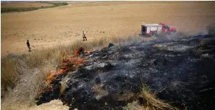  ??  ?? FIREFIGHTE­RS WORK where Palestinia­n arsonists have flown kites and balloons loaded with flammable materials from Gaza onto the Israeli side of the border.