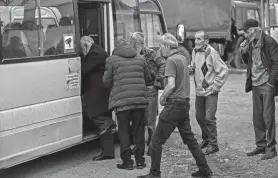  ?? AZIZ KARIMOV/AP ?? Ethnic Armenian men from Nagorno-Karabakh get on a bus leaving the region Sunday. About 80% of the area’s ethnic Armenians have left.