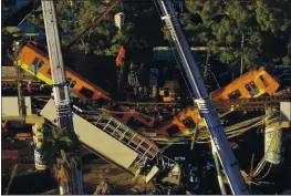  ?? FERNANDO LLANO — THE ASSOCIATED PRESS ?? An aerial view of subway cars dangling at an angle from a collapsed elevated section of the metro in Mexico City on Tuesday. The section collapsed late Monday.