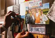  ?? ?? Robinson arranges photos of her children and grandchild­ren on her refrigerat­or.