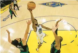  ?? JED JACOBSOHN/AP ?? Andrew Wiggins goes up for a layup against Celtics defenders Derrick White and Al Horford during the Warriors’ 104-94 win in Game 5 of the NBA Finals on Monday.