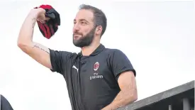  ??  ?? AC Milan striker Gonzalo Higuain throws his jersey to the supporters.
