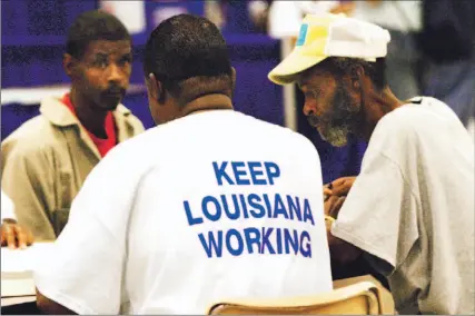  ?? MARIO VILLAFUERT­E/BLOOMBERG PHOTO ?? Two evacuees of Hurricane Katrina speak with a representa­tive from Goodwill Industries, back to camera, at a job fair this week in Shreveport, La. for victims of the storm. Dozens of local employers met with hundreds of evacuees who were interested in finding work.