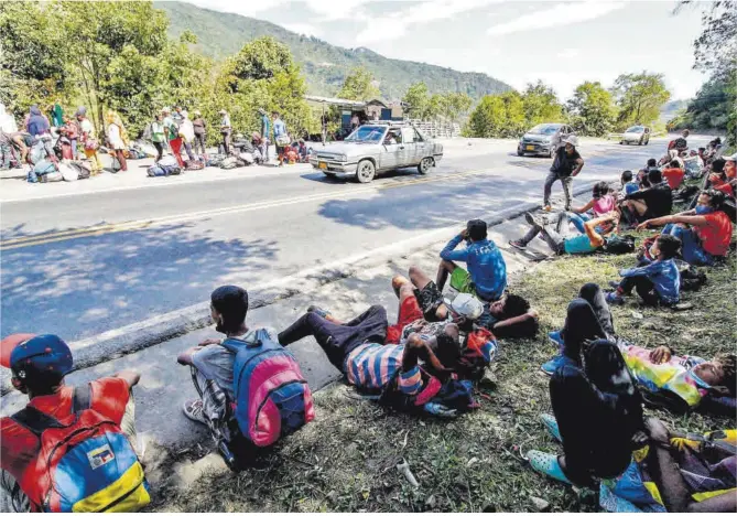  ?? Schneyder Mendoza / AFP ?? Migrants veneçolans esperen l’arribada d’aliments i medicines de la Creu Roja, en una carretera de la ciutat fronterera de Cúcuta (Colòmbia), al febrer.