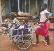  ??  ?? Girls push children in a cart near the market in the town of Hounde, Tuy Province, in southweste­rn Burkina Faso on June 11. (AP/Sam Mednick)