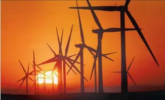  ?? Bob Chamberlin Los Angeles Times ?? SUNRISE at EDF Renewable Energy’s field of wind turbines near Rio Vista, Calif. Renewable energy sources such as wind and solar have grown while their costs have dropped.