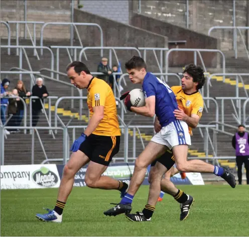  ??  ?? Slane’s Peter Martyn gains possession despite the attentions of Brian Queeney and Tommy Cosgrave during the Junior B Championsh­ip Final at Pairc