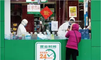  ??  ?? January 26, 2020: A local resident buys medicine at a pharmacy in Wuhan, Hubei Province. by Xiong Qi/xinhua