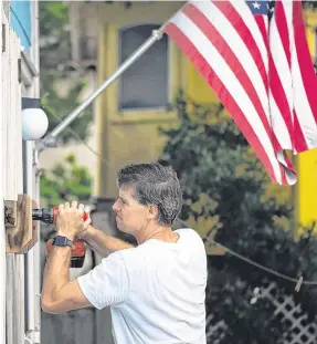  ??  ?? Calm before the storm: A man helps board up Aussie Island surf shop in Wrightsvil­le, North Carolina yesterday in anticipati­on of Hurricane Florence’s high storm surge