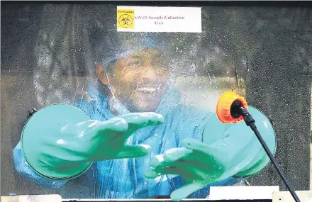  ?? YOGENDRA KUMAR/HT PHOTO ?? A medical worker in an enclosed booth collects swabs for Covid-19 tests during the lockdown in April, at the Old Civil Hospital in Gurugram.